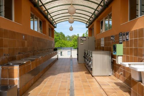 an inside view of a building with sinks and a hallway at Camping Bungalow el Llac de Banyoles in Porqueres