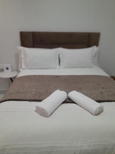a bed with two white towels on it at Ultimate Grace in Pretoria