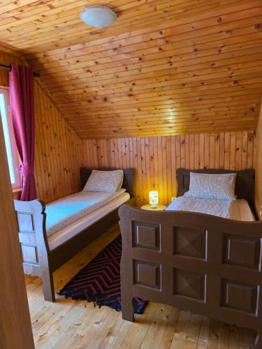 a room with two beds in a wooden cabin at Mountain house Savin Kuk in Žabljak