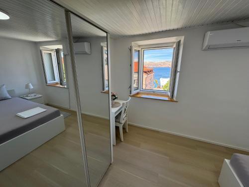 a bedroom with a bed and a sink and a window at Apartment BELLA in Karlobag