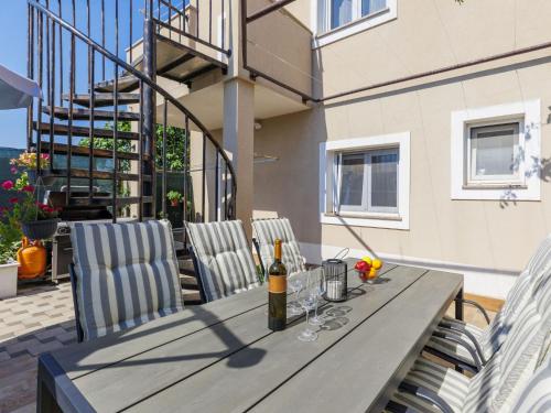 a table with a bottle of wine and two chairs at Apartment L&V by Interhome in Galižana