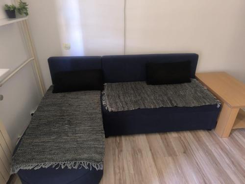 a blue couch in a room with a table at Apartman Točaković in Kladovo