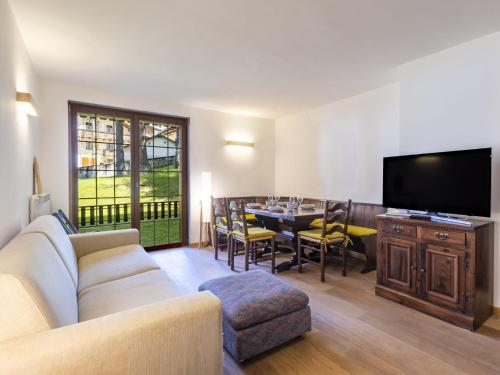 a living room with a couch and a table with a television at Apartment Villa Adele by Interhome in Madesimo
