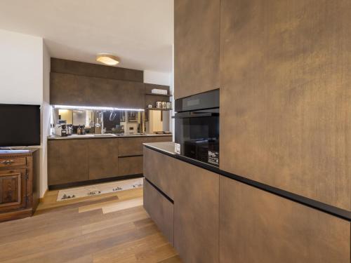 a kitchen with wooden cabinets and a counter top at Apartment Villa Adele by Interhome in Madesimo
