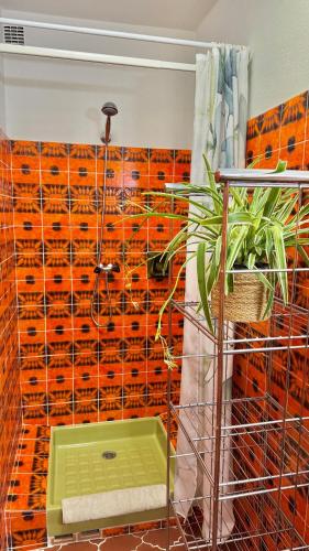 a bathroom with an orange tiled wall at Les Oliviers in Grimaud