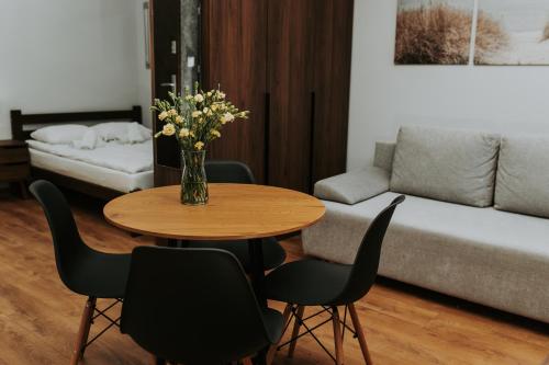 a living room with a table with a vase of flowers at Złota Brama - Old Town Apartment 1 in Gdańsk