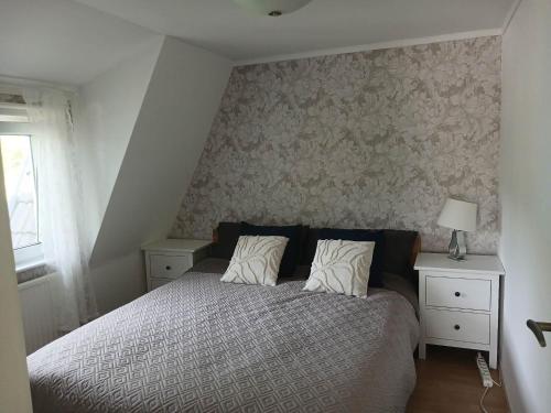 a bedroom with a bed with two night stands and a window at Berghaga in Köping
