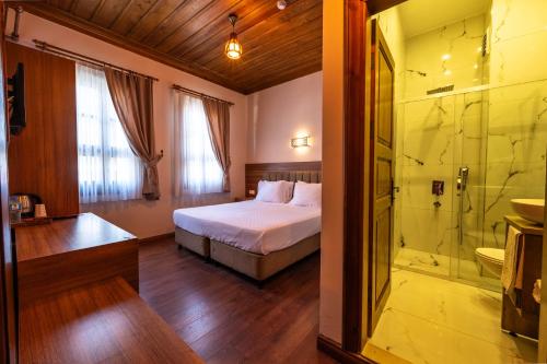 ein Schlafzimmer mit Bett und Glasdusche in der Unterkunft Armistis Hotel in Mudanya