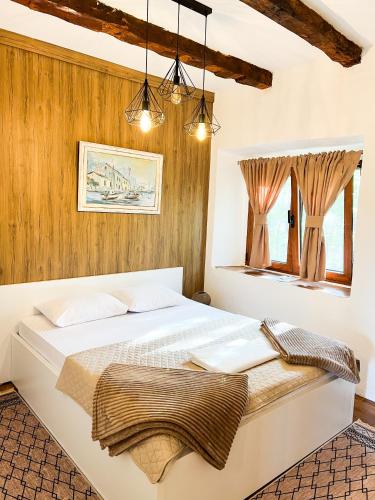 a bedroom with a large white bed and a window at Konoba Stanisic in Balabani