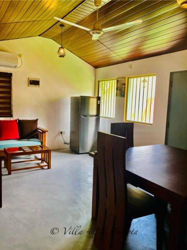 a living room with a table and a refrigerator at Villa 40B Bentota in Bentota