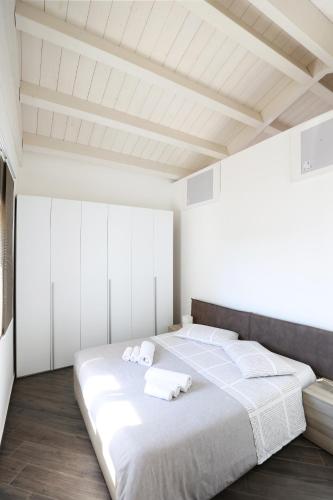 a bedroom with a large white bed with towels on it at A due passi da in Corato