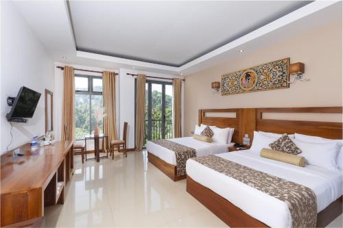 a hotel room with two beds and a television at Rivendell Hotel in Kandy