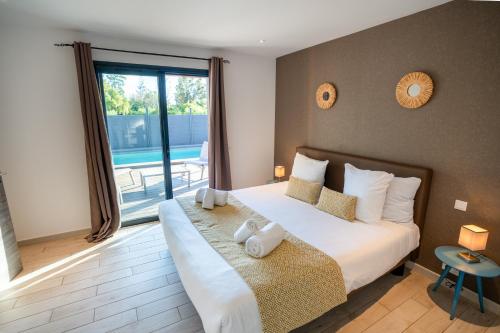a bedroom with a large bed and a large window at Résidence Pierre & Vacances Premium Vesna Rossa in Porto-Vecchio