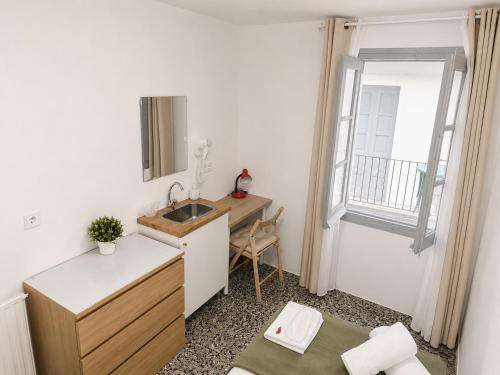 a small bathroom with a sink and a window at Pensión Bandrés Huesca Centro in Huesca
