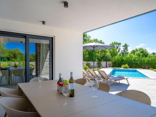a dining room with a table with wine glasses at Villa Dream by Interhome in Dobrinj