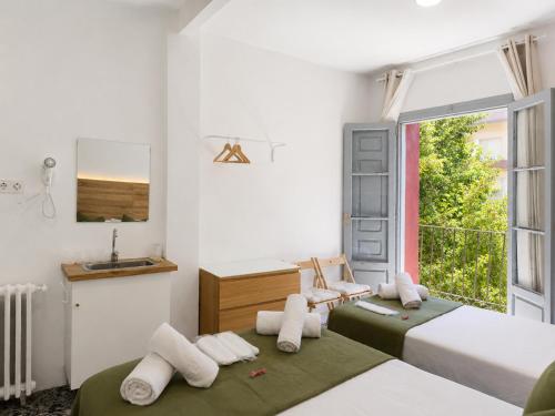 a bedroom with two beds and a window at Pensión Bandrés Huesca Centro in Huesca