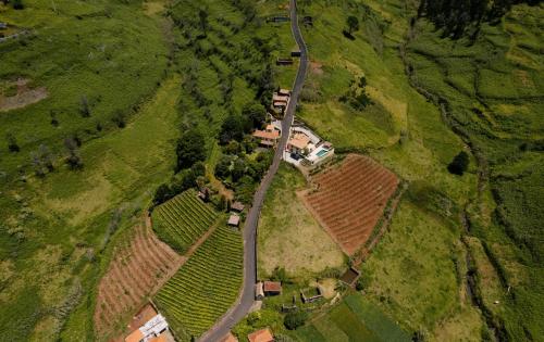an aerial view of a house and a road in a field at Casa da Muda Cottages & Villa in Ponta do Pargo
