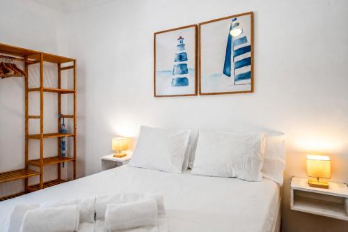 a bedroom with a white bed with two lamps at BeGuest Ferragudo Sunny Apartment in Ferragudo