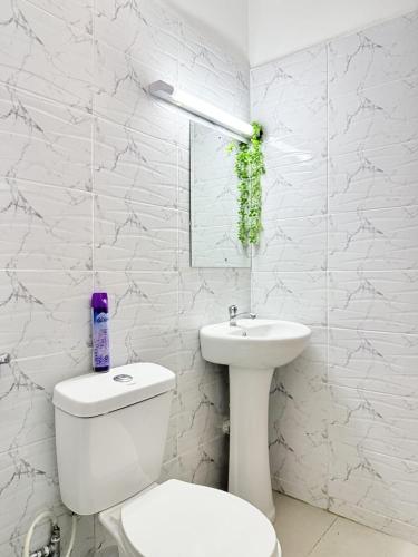 a white bathroom with a toilet and a sink at Ethanira Homes Ngara in Nairobi