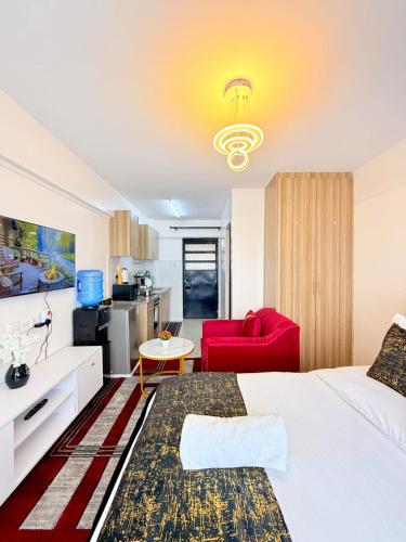 a hotel room with a bed and a red chair at Ethanira Homes Ngara in Nairobi