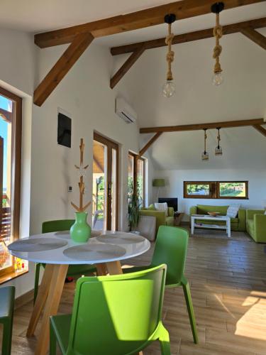 a living room with a table and green chairs at LIPA houses & spa in Sopot