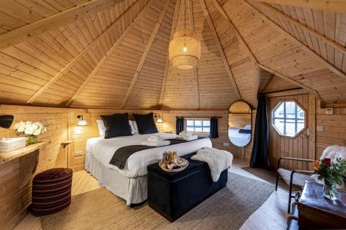 a bedroom with a bed in a wooden room at Scald Law Cabin in Kirknewton