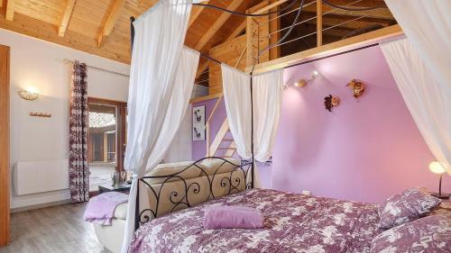a bedroom with a canopy bed with purple walls at Chambres d'hôtes Naturistes (Nudiste) "Cabanadelsol" - Adults Only in Monte da Charneca