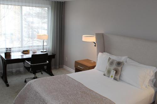 a hotel room with a bed and a desk with a laptop at Erik's Retreat in Edina