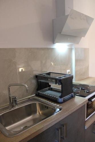 a kitchen sink with a strainer on top of it at Raptis Aparthotel Sivota in Syvota