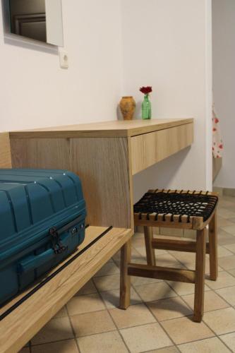 a desk with a blue suitcase and a stool at Raptis Aparthotel Sivota in Syvota
