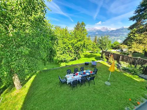 a table and chairs in a yard with mountains at Chalet Chalet Le Rhônasson by Interhome in Vercorin