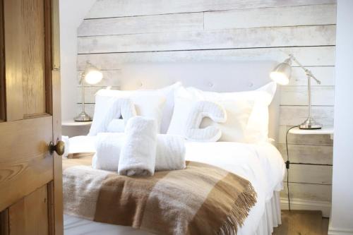 a bedroom with a white bed with white pillows at Abbey Cottages Buzzards Watch in Talley