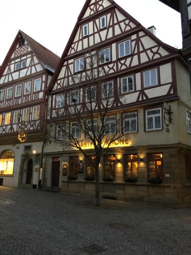 um grande edifício com uma árvore em frente em Brauereigasthof Krone Öhringen em Öhringen