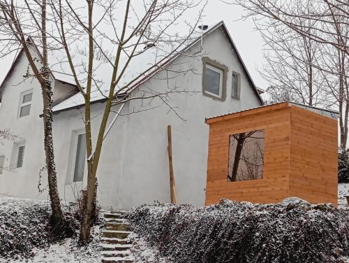 a white house with snow on the ground at Maciejówka in Stará Červená Voda