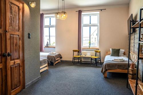 a room with two beds and a table and chairs at 5 Porte in Racibórz