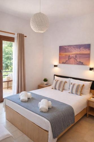 a bedroom with a large bed with towels on it at FILOXENIA by Evita's Resort in Poros