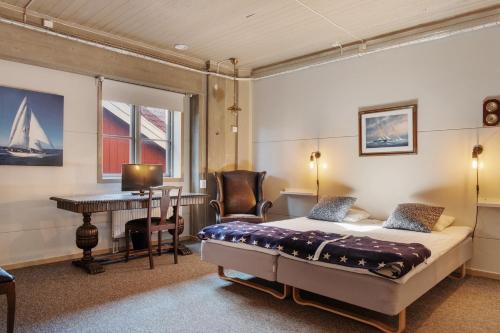 a bedroom with a bed and a desk and a piano at Seglarhotellet Käringön in Käringön