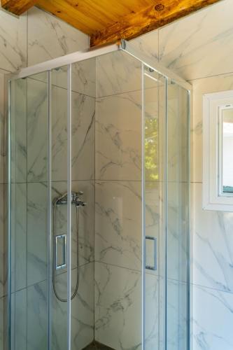 a shower with a glass door in a bathroom at Pappous workplace in Skiathos