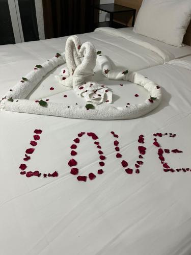 two swans laying on a bed with hearts on it at Hotel Arsenal in Nesebar