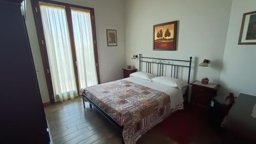 a bedroom with a bed and a large window at La Valle in Villa Verucchio