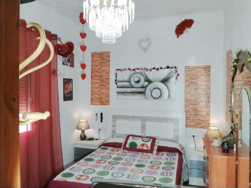 a bedroom with a bed and a chandelier at La casita de la vito in Illar