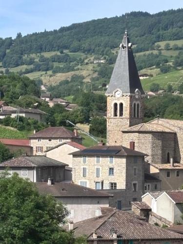 a town with a church with a clock tower at La petite maison in Marchampt