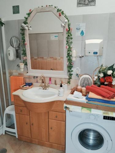 a bathroom with a sink and a washing machine at La casita de la vito in Illar
