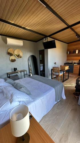 a bedroom with a large bed and a table at Cabana Chácara Vilagio daspedras in Nova Petrópolis