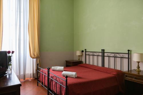 a bedroom with a bed with a red bedspread at Domus Sessoriana in Rome