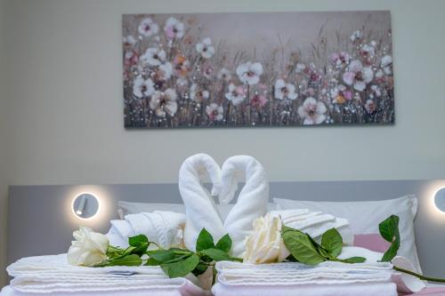 a pile of towels on a bed with a painting at Lima Riverview Suites in Ponte de Lima