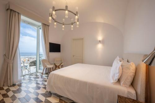 a bedroom with a bed and a chandelier at Bambagina Mare in Amalfi