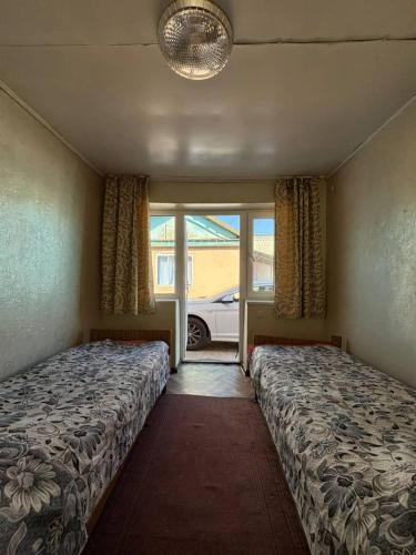 a bedroom with two beds and a window at All Home in Cholpon-Ata