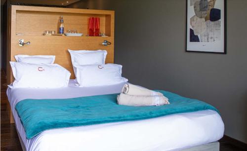 a large bed with white pillows and blue sheets at Le Petit Létraz in Duingt