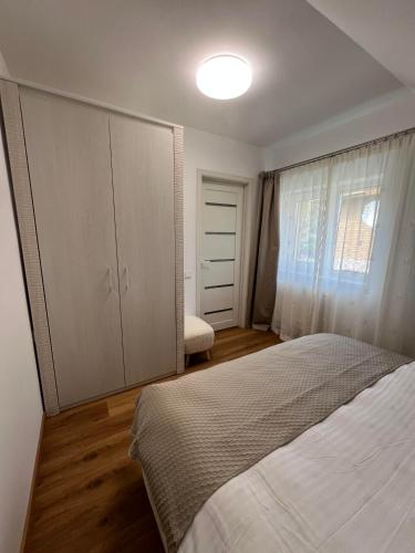 a bedroom with a bed and a large cabinet at Melnragė Dunes Apartment in Melnragė